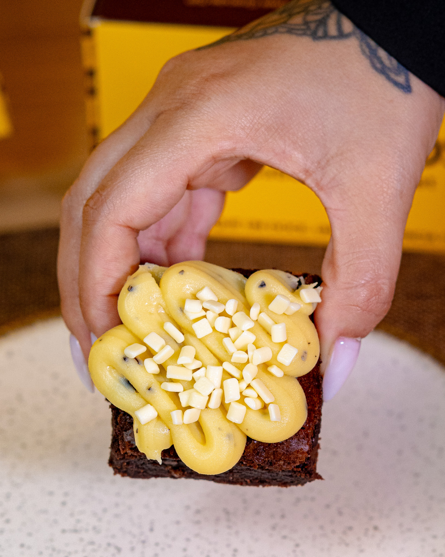Brownie com cobertura cremosa na mão